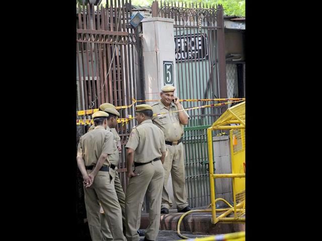 Policemen stand beside barriers at the blast site outside Delhi high court.