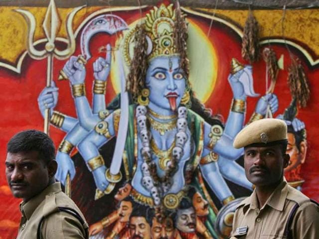 Policemen in Hyderabad stand next to an image of Hindu goddess Kali, the Hindu goddess of power, painted on the wall of a temple during a protest by the main opposition Bharatiya Janata Party (BJP) against the bomb blast outside Delhi's high court.