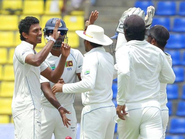 Sri Lanka's Suraj Randiv (L) celebrates with teammates taking the wicket of Australia's Phillip Hughes during the second day of their second Test cricket match against Australia in Kandy.