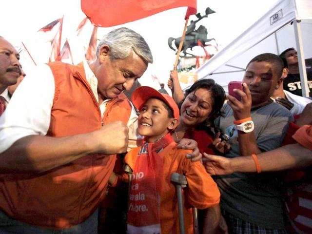 Guatemala's presidential candidate Otto Perez Molina (L) from the Patriot Party (PP) interacts with a young supporter before his final political rally ahead of elections in Guatemala City.