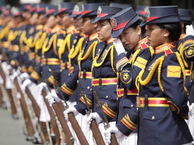 A member of the Philippine National Police (PNP) honour guard wipes off her sweat as they wait in line for the start of the PNP Change of Command Ceremonies at Camp Crame in Quezon City, Metro Manila.