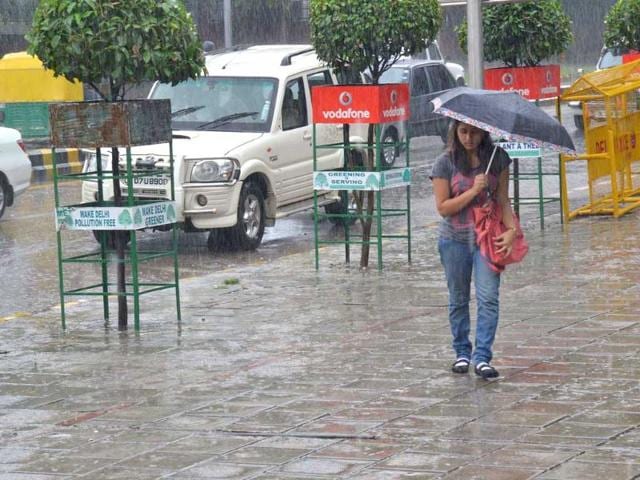 A girl trying to protect herself as it rains heavily in New Delhi.