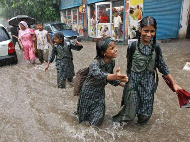 School children walk back home through a flooded street after heavy monsoon rains in New Delhi.