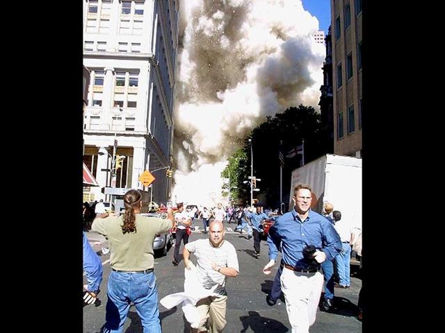 Pedestrians run from the scene as one of the World Trade Center Towers collapses on 11 September, 2001 in New York following a terrorist plane crash on the twin towers. File photo