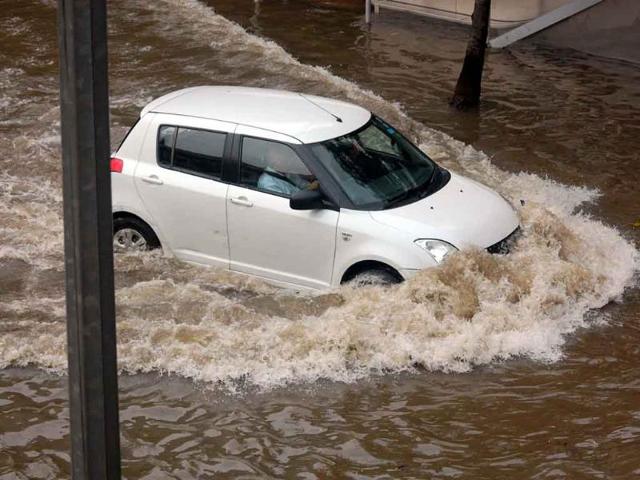 A car wading through a waterlogged street at ITO during heavy rains in New Delhi.