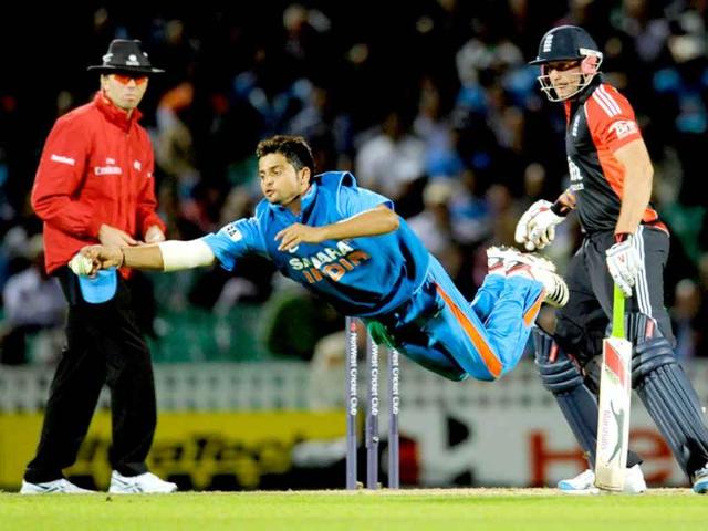 Suresh Raina dives to stop a ball watched by England's Tim Bresnan and umpire Nigel Llong during the third one-day international cricket match at the Oval cricket ground in London.