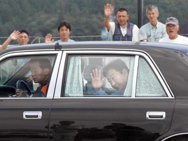 Japan's Prime Minister Yoshihiko Noda (C) waves to local residents during his inspection tour at a fish market in Kesennuma, Miyagi prefecture.