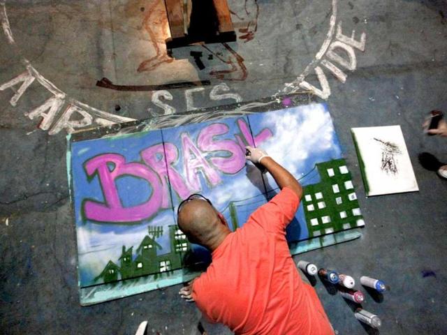 Artist Ograo sprays a painting during a graffiti class at Sao Mateus em Movimento, the headquarters of OPNI, an organization that uses graffiti to improve life in the slums, in the Vila Flavia favela of Sao Paulo.
