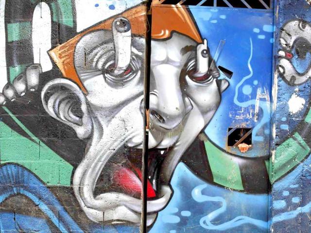 A woman opens the door of her home painted with graffiti from Brazilian artist Shock working with OPNI, an organization that uses graffiti to improve life in the slums, in the Vila Flavia favela of Sao Paulo.