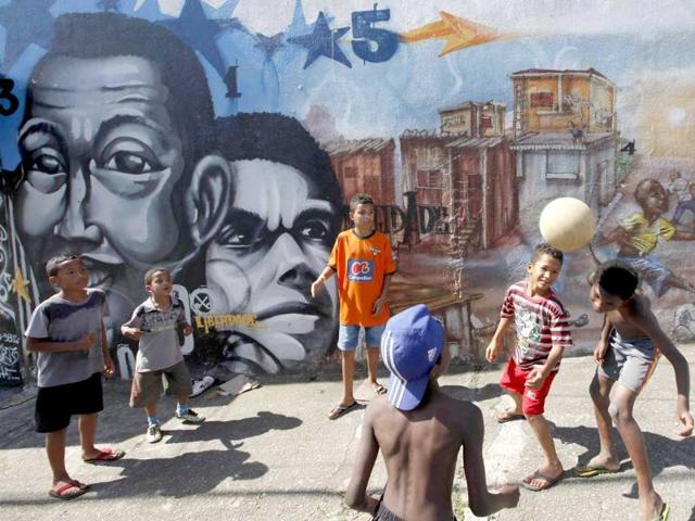Children play in front of graffiti painted by artists of OPNI, an organization that uses graffiti to improve life in the slums, in the Vila Flavia favela of Sao Paulo.