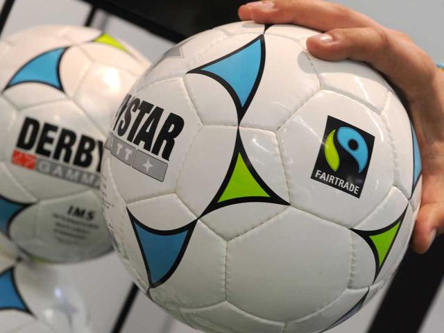A man holds a "Derbystar" football, manufactured in Pakistan, in Dortmund, western Germany, during the "Fair 2011" an exhibition for fair trade.