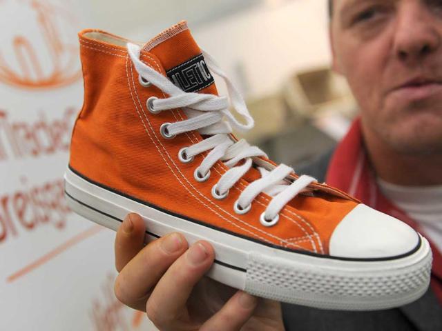 German distributor Thilo Rau holds a fair trade sneaker shoes made with rubber from India and cotton from Sri Lanka, in Dortmund, western Germany, during the "Fair 2011" a exibition for fair trade.