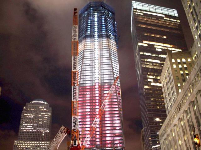 The Freedom Tower at the World Trade Center site which is lit in red, white and blue is viewed.