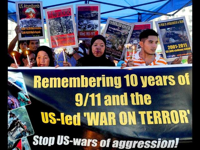 Filipino Muslims and Christians join together as they hold a banner and placards in Manila on September 10, 2011 to commemorate the 10th anniversary of September 11 terror attacks in New York City.