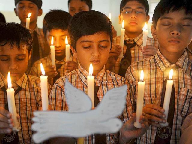 School children hold candles as they pay tribute to those killed in the September 11, 2001 attacks on New York's World Trade Centre twin towers, at a public school in Amritsar.