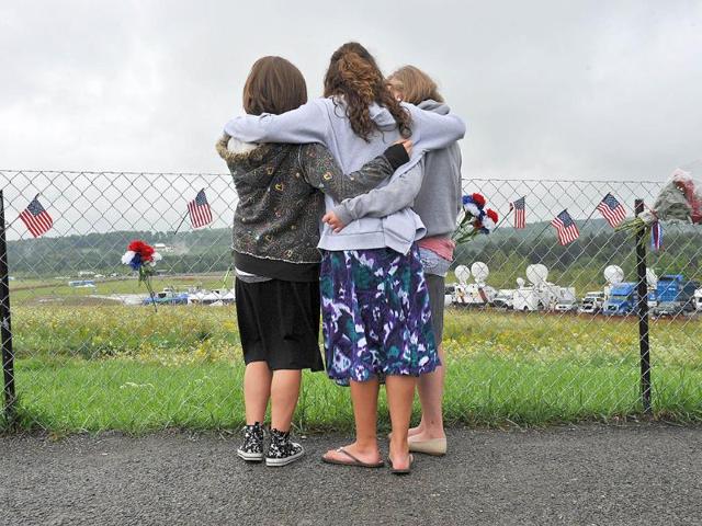 Courtney Peeler (R), 14, Taylor Duffy (C) and Caitlin Rakowski, both 15, embrace as they look at the field in Shanksville, Pennsylvania.