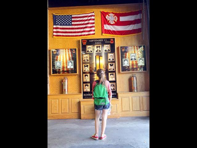 A girl looks at a memorial to firefighters killed at FDNY Engine 24 and Hook and Ladder 5 on September 9, 2011 in New York City. 343 firefighters were killed in the September 11, 2001 terror attacks.