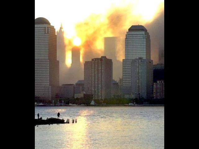 Smoke from the destroyed World Trade Center rises over the southern end of New York City's Manhattan Island nearly blocking the sunrise as seen from Jersey City, New Jersey in the early morning, 12 September, 2001. Terrorists hijacked two commercial airliners and crashed them into each of the towers of the Trade Center. File photo