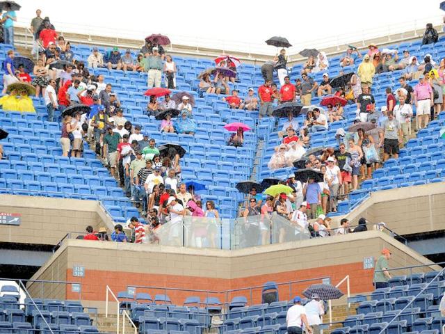 Fans leave their seats at Arthur Ashe Stadium court as rainfall delays the Men's semifinal match between number one seed Novak Djokovic of Serbia and number three seed Roger Federer of Switzerland at the US Open tennis tournament.