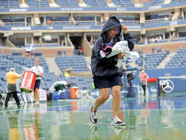 A line judge leaves Arthur Ashe Stadium court as rainfall delays the Men's semifinal match between Novak Djokovic and Roger Federer at the Men's semifinal 2011 US Open match.