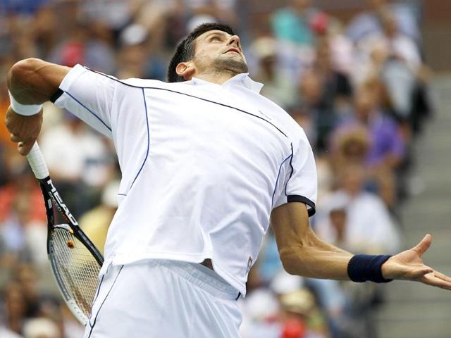 Novak Djokovic serves to Roger Federer of Switzerland during a semifinal match at the US Open tennis tournament in New York.