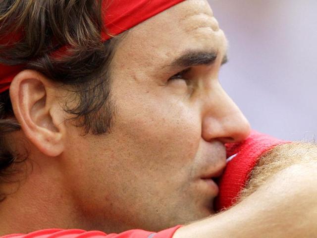 Roger Federer wipes his face during a semifinal match against Novak Djokovic of Serbia at the US Open tennis tournament in New York.