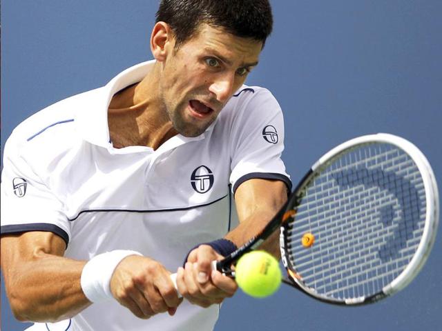 Novak Djokovic returns a shot to Roger Federer during a semifinal match at the US Open tennis tournament in New York.