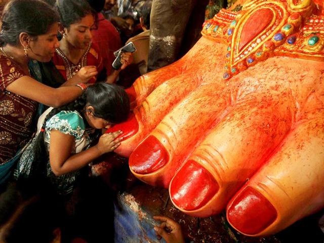 A child worships the feet of an idol of elephant-headed Hindu God Ganesha during the Ganesh Chaturthi festival in Hyderabad.