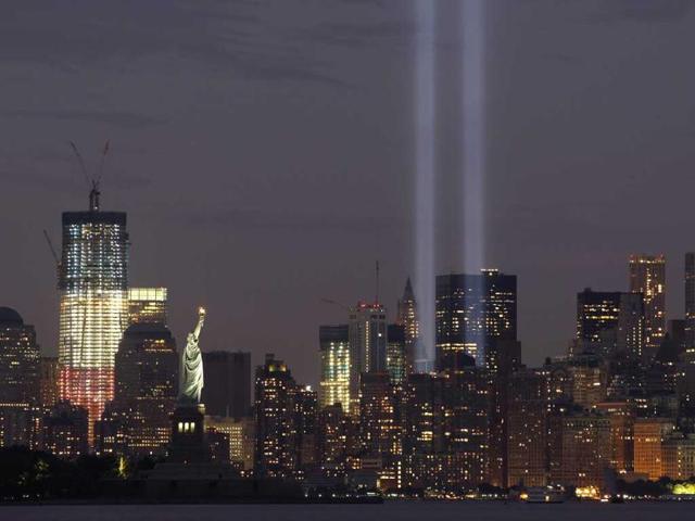 The Tribute in Lights is illuminated next to One World Trade Center (L) and the Statue of Liberty (C) during events marking the 10th anniversary of the 9/11 attacks on the World Trade Center in New York.