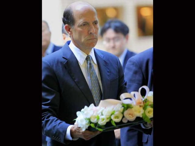 US Ambassador John Roos carries flowers to place the wreath at a makeshift altar during a memorial service to mark the 10th anniversary of the 9/11 terrorist attacks on the United States, at the Mizuho Financial Group Inc. headquarters in Tokyo.