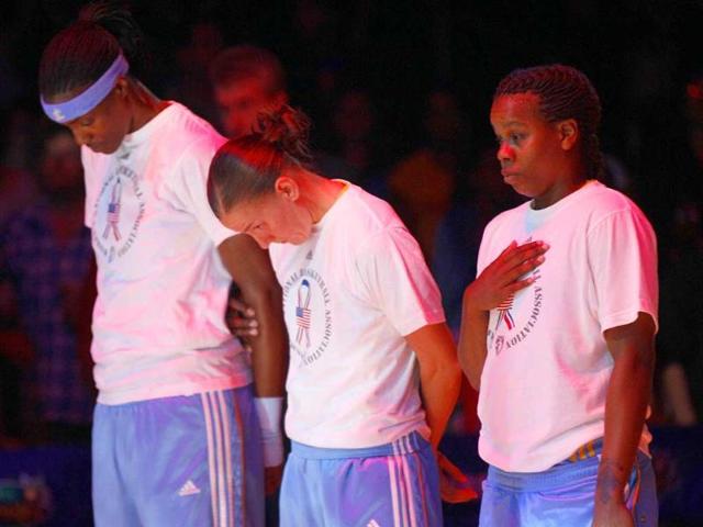 Chicago Sky's Sylvia Fowles (L) Erin Thorn and Epiphanny Prince (R) stand for a moment of silence in observance of the 10th anniversary of the 9/11 attacks before a WNBA basketball game against the Los Angeles Sparks in Los Angeles.