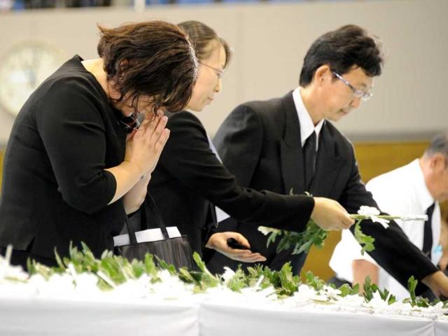 Residents place flowers and mourn at an alter dedicated to the March 11 earthquake and tsunami victims in the town of Minamisanriku, Miyagi prefecture at a ceremony marking the six-month anniversary of the twin disasters.