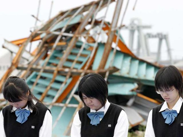Schoolgirls observe a minute of silence for victims of the March 11 earthquake and tsunami in Ishinomaki, Miyagi Prefecture, six months after the area was devastated by the 9.0 magnitude disaster.