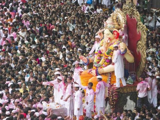 Devotees gather around a huge idol of Lord Ganesha during its procession for immersion into the Arabian Sea, on the streets of Mumbai.