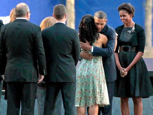 US President Barack Obama (2nd R) embraces victims' family members as first lady Michelle Obama (R) stands by at the 9/11 Memorial in New York City.
