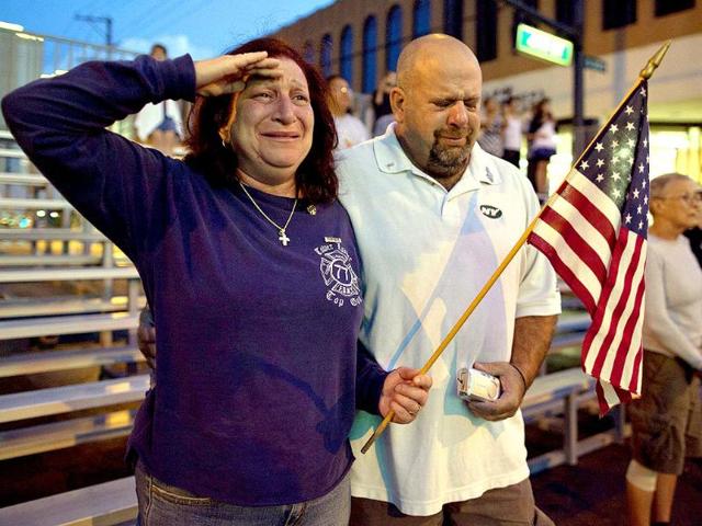 Lisa (L), and John Karounos of Las Vegas, watch as a parade commemorating the 2001 attacks on the World Trade Center and the Pentagon marches along Fourth Street in Las Vegas.