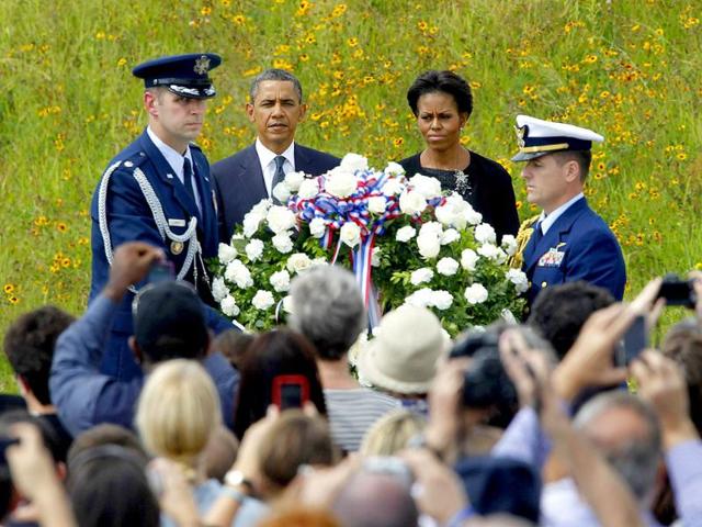 US President Barack Obama and frst lady Michelle Obama look on as military personal place a wreath during ceremonies marking the 10th anniversary of the 9/11 attack in Shanksville, Pennsylvania.