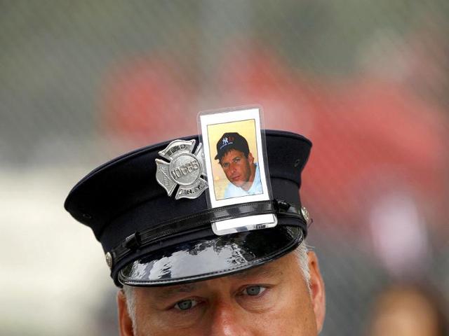 A New York firefighter with the image of a fellow firefighter Brian McAleese in his cap, attends ceremonies marking the 10th anniversary of the 9/11 attacks on the World Trade Center, in New York, September 11, 2011.