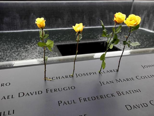 Roses are placed in the name of a person killed during the Sept. 11 World Trade Center attacks, etched in the area surrounding a reflecting pool of the Sept. 11 memorial, during 10th anniversary commemoration ceremonies at the site, in New York