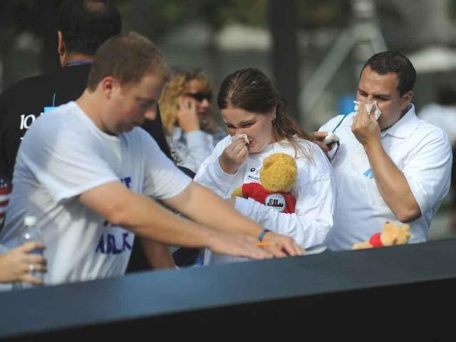 A man makes an impression of a name on the wall of the September 11 Memorial, as families who lost loved ones join the public in the 10th anniversary commemoration of the terrorist attacks on the World Trade Center in New York.