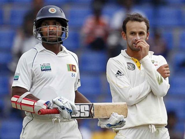 Sri Lankan batsman Kumar Sangakkara runs between wickets as Australia's bowler Nathan Lyon reacts during the fourth day's play of their second Test cricket match in Pallekele, Sri Lanka.