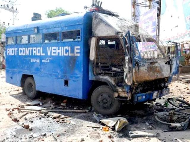 A police van sits destroyed near a store front after it was attacked by an angry mob in Paramakudi, 40 km from Ramanathapuram.
