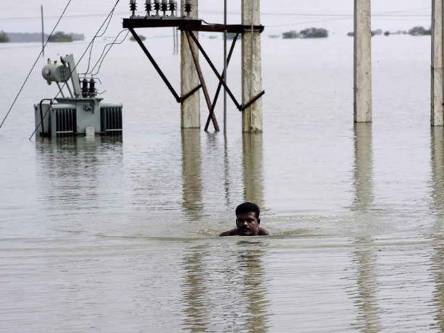 A villager swims through floodwaters, past a submerged electric transformer near Baghamari, about 30 kilometers from Bhubaneshwar.