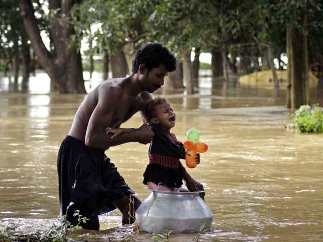 A man pushes his child through floodwaters in a vessel after their home was flooded by the rising waters of the River Mahanadi on the outskirts of Cuttack, about 30 kilometers from Bhubaneshwar.