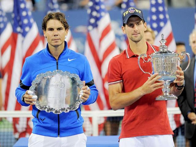 Novak Djokovic (R) and Rafael Nadal pose for photographs with their trophies after the men's US Open final at the USTA Billie Jean King National Tennis Center in New York.