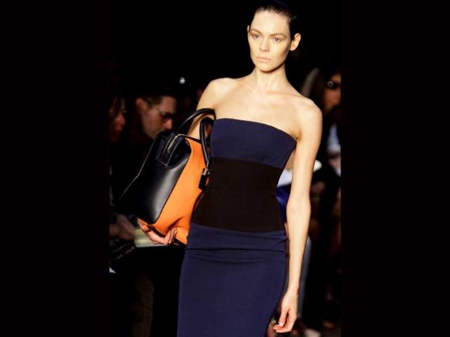 A striking orange bag to go with dark tube top and hugging skirt.