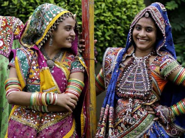 Girls wearing traditional attire react to the camera as they practice the Garba, a traditional dance of Gujarat, as part of preparation for Navratri festival in Ahmedabad.