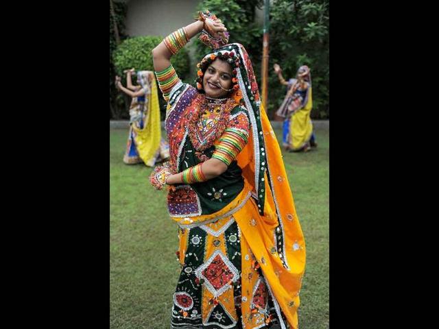 A folk dancer poses with her troupe during a full dress rehearsal for the forthcoming Navratri festival.