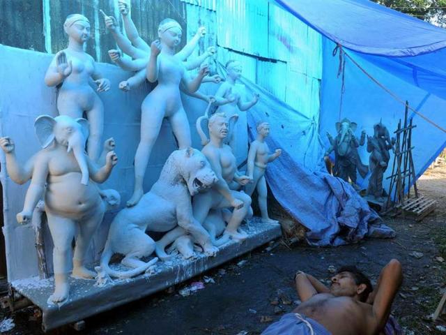 An Indian artisan rests near clay idols of Hindu deities in Kumartoli, the idol makers village of Siliguri. Monsoon rain has made it difficult for artisans to finish idols on schedule, with the recent economic slowdown and rising inflation adding to the difficulties of the artisans ahead of the Durga Puja festival to be celebrated in October.