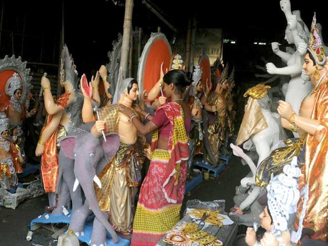 An artisan works on clay idols of Hindu deities in Kumartoli, the idol makers village of Siliguri.